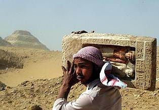 An Egyptian worker carries an ancient stone statue of the deceased Meri, left, and his wife, found at a tomb with ancient wooden coffins dating back to the 26th Pharaoh Dynasty that ruled from 672 BC to 525 BC, seen in Sakkara Wednesday, March 2, 2005, 10 kilometers south of Cairo. Australian archaeologists have discovered one of the best preserved ancient Egyptian mummies dating from about 2,600 years ago, Zahi Hawass, the head of Egypt's Supreme Council for Antiquities said .(AP Photo/Amr Nabil)