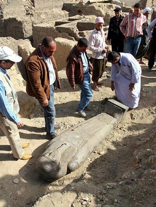 Egyptian antiquities experts and workers gather around one of three newly discovered sarcophagi at the Saqqara pyramids near Cairo March 2, 2005. Australian archaeologists have discovered one of the best preserved ancient Egyptian mummies dating from about 2,600 years ago, Zahi Hawass, the head of Egypt's Supreme Council for Antiquities said. REUTERS/Aladin Abdel Naby