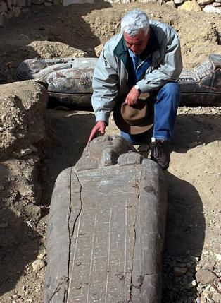 Zahi Hawass, the head of Egypt's Supreme Council for Antiquities, inspects one of three newly discovered sarcophagi at the Saqqara pyramids near Cairo March 2, 2005. Australian archaeologists have discovered one of the best preserved ancient Egyptian mummies dating from about 2,600 years ago, Hawass said. REUTERS/Aladin Abdel Naby