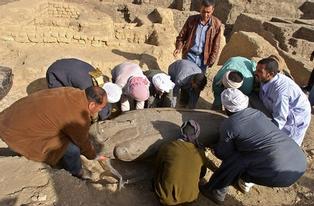 Egyptian workers carry an ancient wooden coffin, shaped like a human body that dates back to the 26th Pharaoh Dynasty that ruled from 672 BC to 525 BC, in Sakkara, south of Cairo Wednesday, March 2, 2005. Australian archaeologists have discovered one of the best preserved ancient Egyptian mummies dating from about 2,600 years ago, Zahi Hawass, the head of Egypt's Supreme Council for Antiquities said. (AP Photo/Amr Nabil)